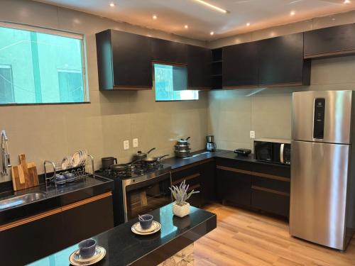 ベレンにあるApartment in Belém - Círio and COP30のキッチン(黒いカウンター、ステンレス製の冷蔵庫付)