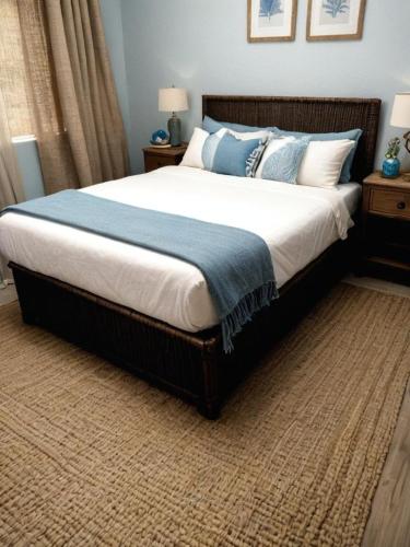 a bedroom with a large bed with blue pillows at Atlantic VIews Moullie Point in Cape Town