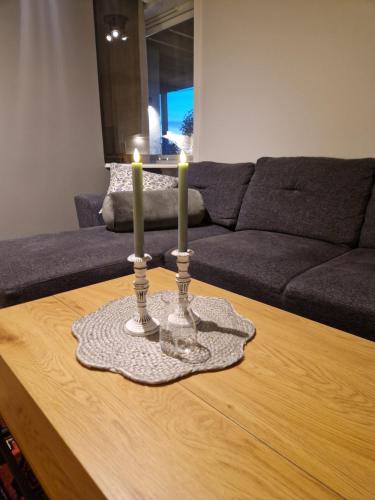 two candles on a coffee table in a living room at Warm and cosy apartment in Tromsø