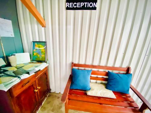 a wooden bench with two blue pillows next to a desk at Nomads Family Rooms, Fortuna Town in Fortuna