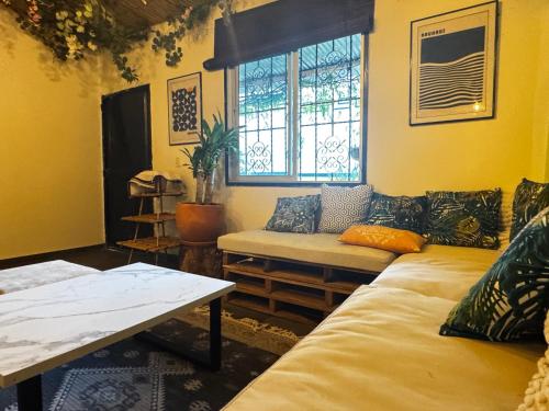 Una sala de estar con un sofá y una ventana. en Casa Colibri - Hostel, en Pueblo Bello