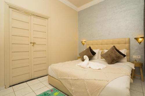a bedroom with a bed with a swan on it at Résidence alqaria assiyahiya in Marrakech