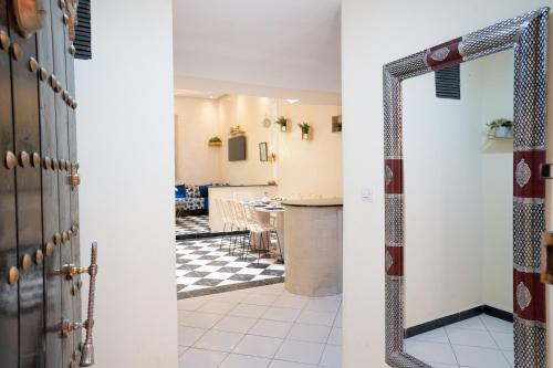 a hallway with a mirror and a kitchen with a table at Résidence alqaria assiyahiya in Marrakech
