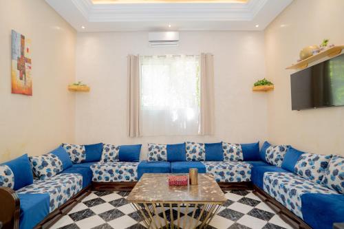 a living room with a blue couch and a table at Résidence alqaria assiyahiya in Marrakech