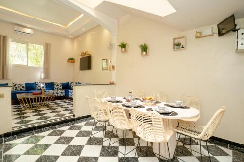 a dining room with a table and chairs at Résidence alqaria assiyahiya in Marrakech