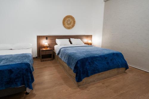 a bedroom with two beds with blue sheets at Casa Grace Olón in Olón