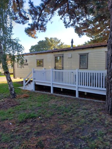 a mobile home with a white fence at Lovely 3 bedroom caravan haven wild duck hoilday Park in Belton