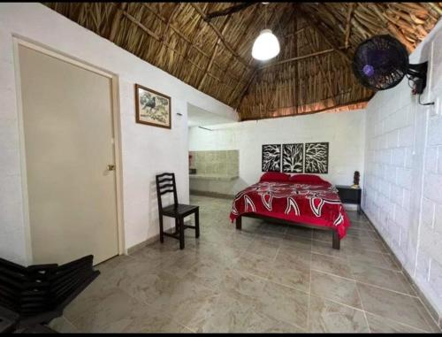 a bedroom with a red bed and a chair at Quinta Flor de Mayo 