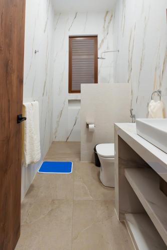 a bathroom with a toilet and a blue rug at Casa Grace Olón in Olón