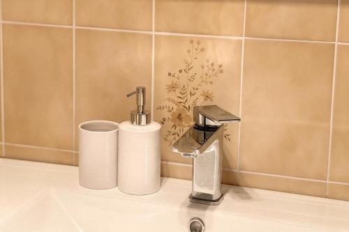a bathroom sink with a faucet and two paper towels at 3 Bedroom Deluxe Family Home in Rooty Hill