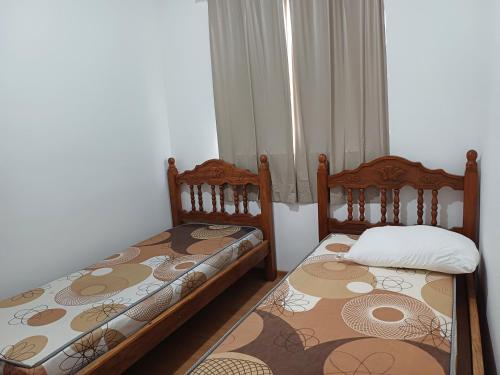 two beds sitting next to each other in a room at Apto central 3104 terreo com ar condicionado in Araçatuba