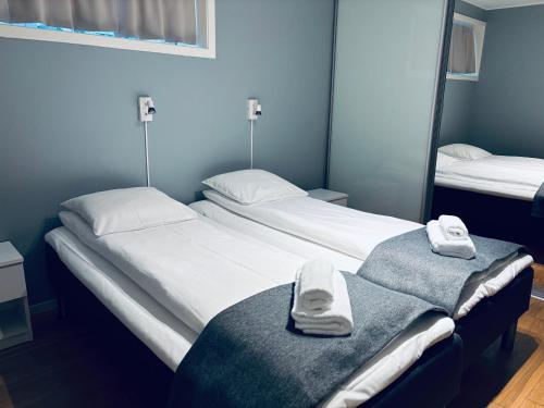 deux lits dans une chambre avec des serviettes dessus dans l'établissement Bergen Centrum Modern Apartment, à Bergen