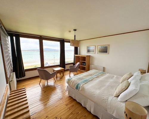 a bedroom with a bed and a table and chairs at Weskar Lodge Hotel in Puerto Natales