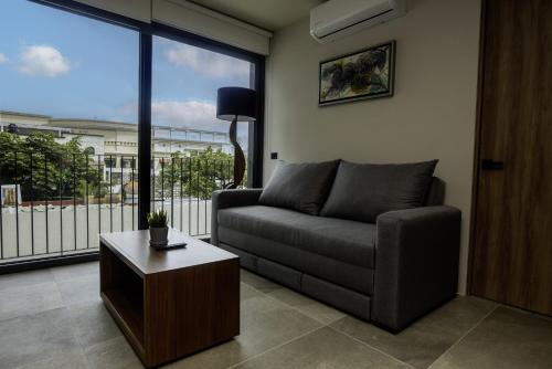 a living room with a couch and a large window at Cozy Americana Condo GDL in Guadalajara
