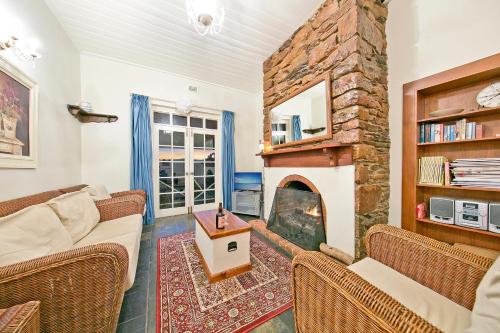 a living room with a large stone fireplace at Vineyard Cottage BnB in Gumeracha