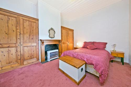 1 dormitorio con 1 cama y chimenea en Vineyard Cottage BnB, en Gumeracha