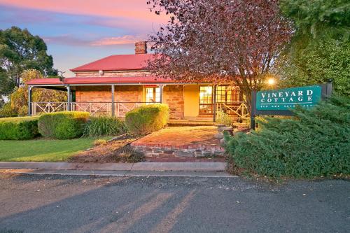 a house with a sign in front of it at Vineyard Cottage BnB in Gumeracha