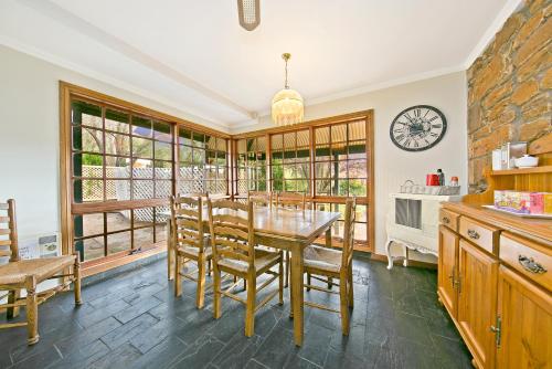 cocina con mesa de comedor y sillas en Vineyard Cottage BnB, en Gumeracha
