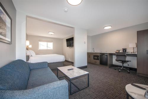 a hotel room with a couch and a bed at Coast Penticton Hotel in Penticton