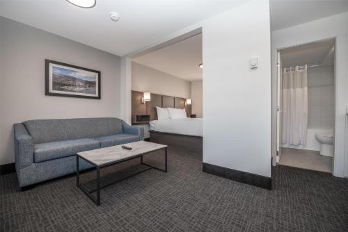 a hotel room with a couch and a bed at Coast Penticton Hotel in Penticton