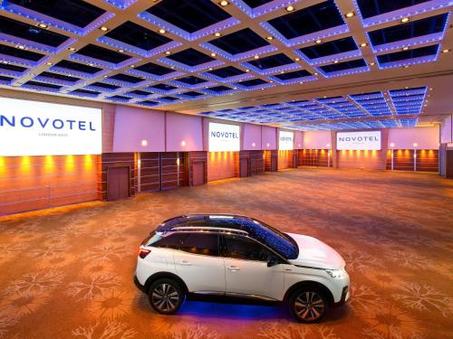 a white car parked in a large room at Novotel London West in London
