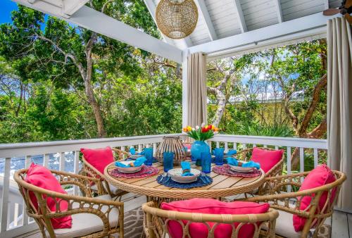 una mesa y sillas en un porche con vistas a los árboles en Serenity Oasiskayaksbikes!spapool!, en Long Point Key