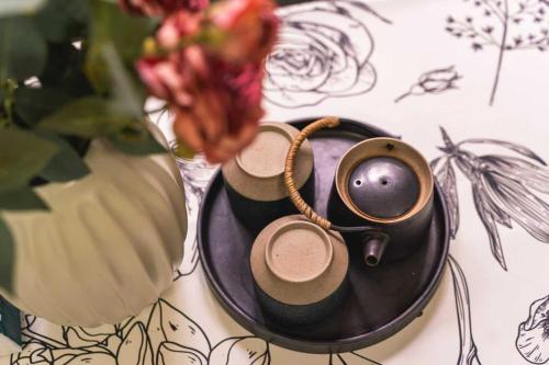 a table with a plate with a cup and a pair of headphones at 柃居 B&B - Jing'an Temple Branch in Shanghai