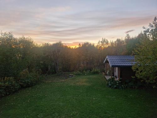 a small shed in a yard with the sunset in the background at Aurora view apartment in Tromsø