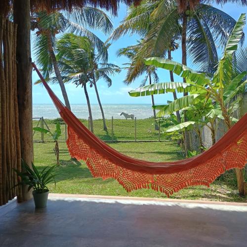 a hammock in a room with a view of the beach at PanaPaná in Maxaranguape