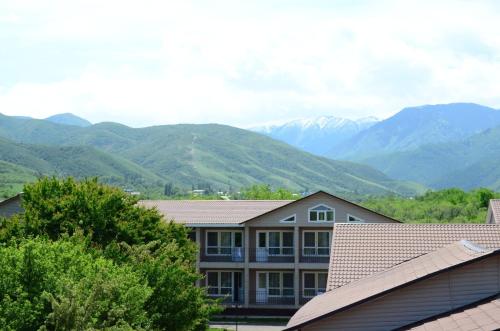 - une vue sur une maison avec des montagnes en arrière-plan dans l'établissement Densaulyq Resort & Wellness - Almaty Region, à Taūtürgen
