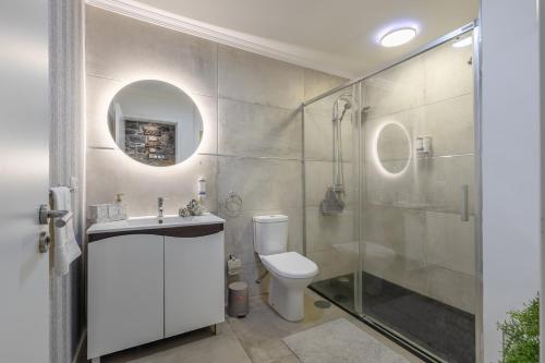 a bathroom with a toilet and a glass shower at Little Townhouse Funchal in Funchal
