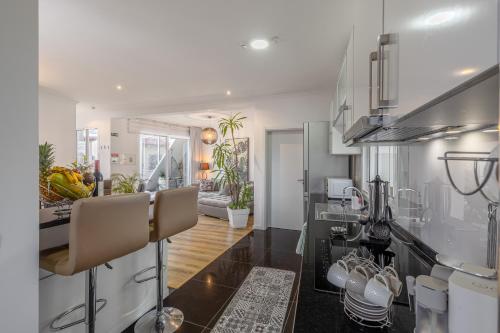 a kitchen and living room with white walls and a counter at Little Townhouse Funchal in Funchal