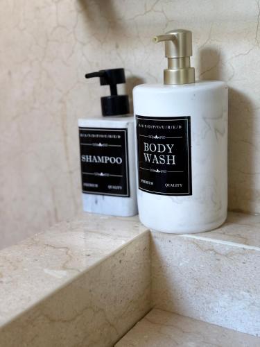 two bottles of soap sitting on a bathroom sink at Résidence alqaria assiyahiya in Marrakech