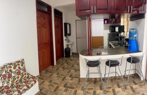 a kitchen with a counter and some bar stools at Apartment Laureles in Santa Lucía