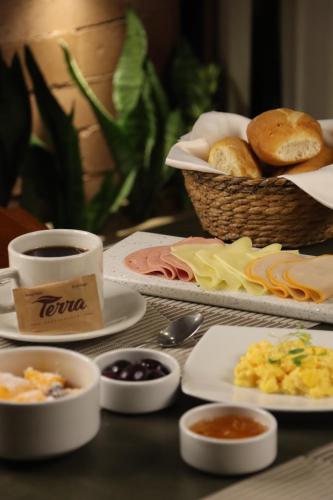 a table with plates of food and a cup of coffee at Rado Hotel - Quintanas in Trujillo
