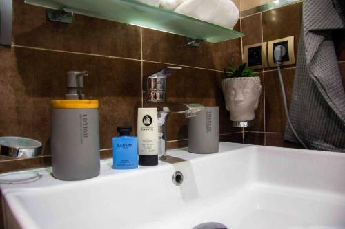 - un lavabo dans la salle de bains avec 2 bouteilles d'odorisants dans l'établissement Cozy apartment in Rabat Agdal, à Rabat