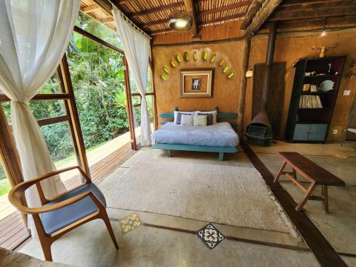 a bedroom with a bed and a chair in a room at Tejase in Araras Petropolis