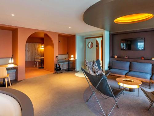 a living room with a blue couch and chairs at IBIS STYLES Rouen Parc Expos Zenith in Saint-Étienne-du-Rouvray