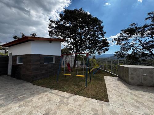 a house with a playground in the yard at Sítio com 2 Piscinas em Arujá in Arujá