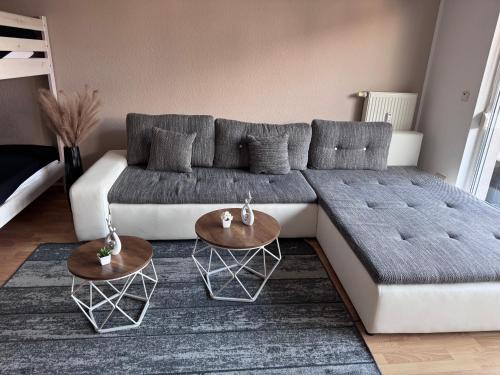 a living room with a couch and two tables at Ferienwohnung Michelle - auf Wunsch klimatisiert für 20,- Aufpreis pro Nacht in Rust