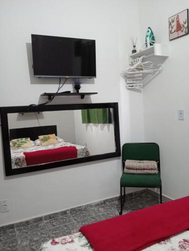 a room with a mirror and a chair and a tv at Fontinele's Home Apt 201 in Nova Iguaçu