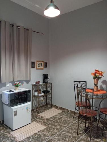 a kitchen with a table and a microwave at Fontinele's Home Apt 201 in Nova Iguaçu