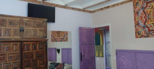 Una habitación con puertas moradas en la pared. en BED FOR 4. TYPICAL QUIET AND AUTHENTIC AREA, en Córdoba