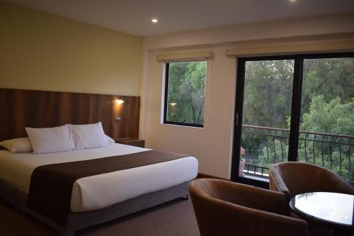 a hotel room with a bed and a balcony at Hotel Villa del Carmen in Arequipa