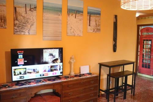 TV de pantalla plana en la parte superior de una cómoda de madera en Apartamento La Venencia, en Jerez de la Frontera