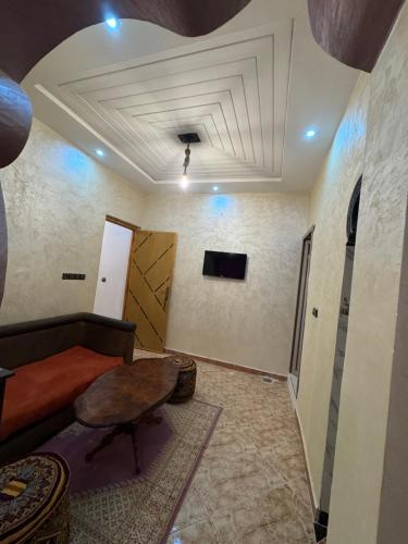 a living room with a coffered ceiling and a table at Riad Restaurant Mifis in Rissani