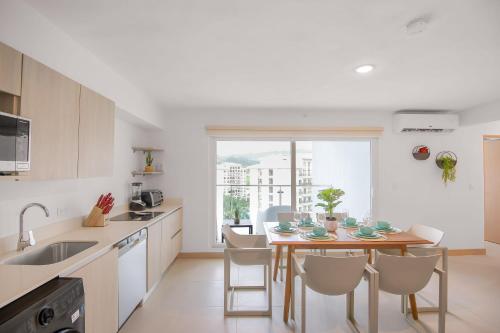 a kitchen with a table and chairs in a kitchen at Incredible Views - Brand-New 3BR Condo in Jacó