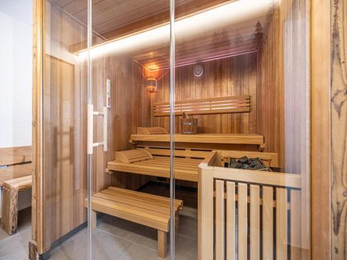 a sauna with wooden walls and wooden benches at Tirola Chalet Alpbach in Alpbach