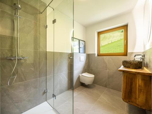 a bathroom with a shower and a toilet and a sink at Tirola Chalet Alpbach in Alpbach