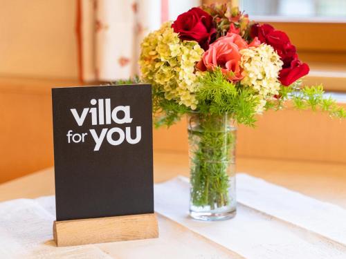a vase with flowers and a sign on a table at Chalet Georg in Zellbergeben